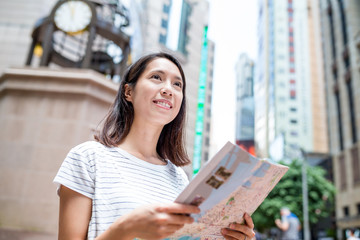 Wall Mural - Young woman using city guide in Hong Kong