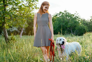 Wall Mural - girl playing with labrador retriever dog in park