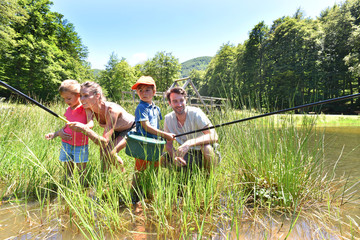 Wall Mural - Family fishing in lake on a sunny day