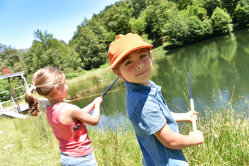 Wall Mural - Portrait of little girl fishing by mountain lake