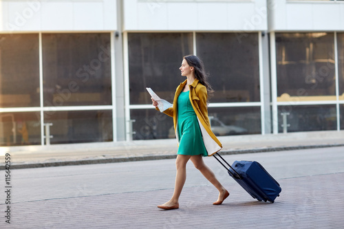 Fotografie, Obraz happy young woman with travel bag and map in city
