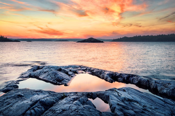 Wall Mural - stone shore of the lake at sunset
