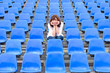 Glum woman sitting in spectator seating