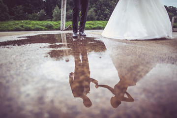 Wall Mural - Wedding couple reflect in water puddle