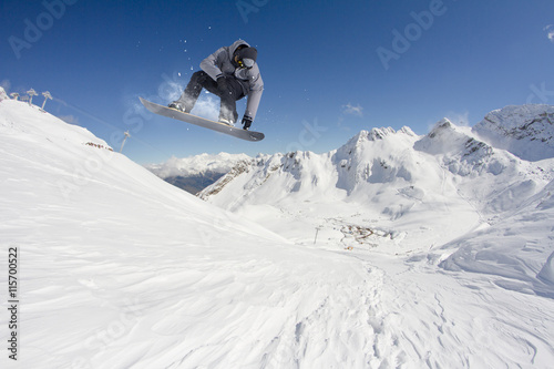Fototapeta na szkło Jeźdźca snowboarding skoki na górach. Ekstremalny snowboard freeride sport.