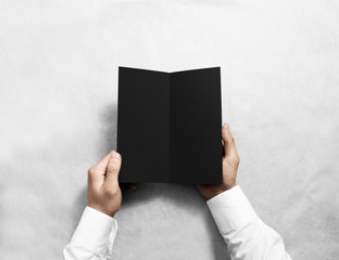 Fototapete - Hand opening blank black flyer brochure booklet mockup. Leaflet presentation. Pamphlet mock up holding hand. Man show grey offset paper. Booklet design template. Paper sheet display read first person
