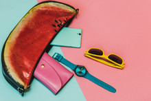 Flat Lay Fashion Set: Bag With Watermalon Print, Pink Purse, Mint Colored Smartphone, Yellow Sunglasses And Blue Watch On Pastel Colored Background