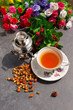 Чай, декоративный самовар и  ягоды шиповника на фоне ярких декоративных цветов. Вид сверху.