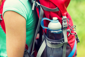 Canvas Print - close up of woman with water bottle in backpack