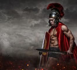 Male in spartan costume holding sword and shield.