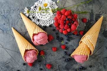 Poster - Raspberry ice cream with ice cream cones on stone table.