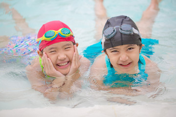 Happy Asian sibling girl playing in the swimming pool