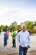 © Astrakan Images - Portrait of man holding balls while playing boule with friends at park
