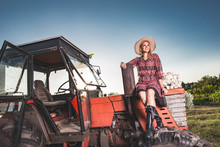Young Farmer Woman Posing On Red, Old Tractor.