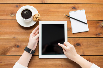 Poster - close up of woman with tablet pc on wooden table