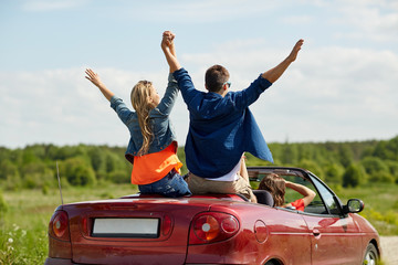 Wall Mural - happy friends driving in cabriolet car at country