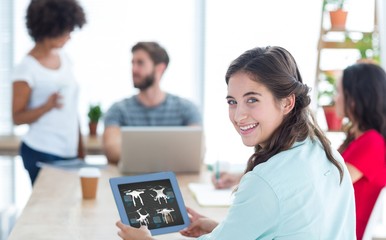 Poster - Composite image of smiling businesswoman using tablet 
