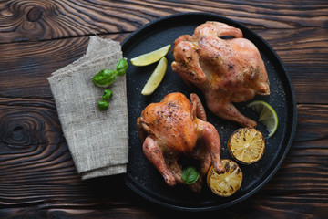 Canvas Print - Frying pan with a pair of whole roasted chickens, above view