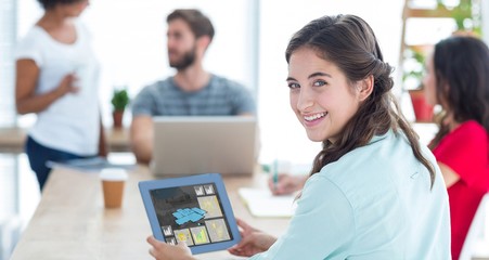 Poster - Composite image of smiling businesswoman using tablet 