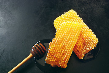 Two pieces of fresh honeycomb with a dipper