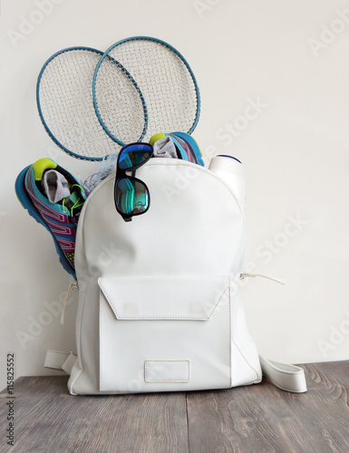 Fotografie, Obraz White leather bag (daypack) with sport shoes, sunglasses and badminton battledor