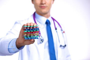 A young doctor holds the patient's hand with pills