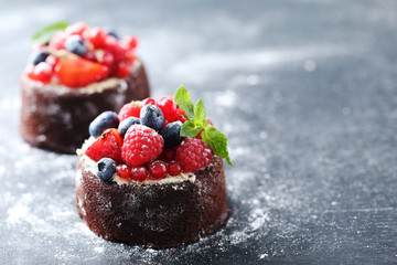 Wall Mural - Sweet chocolate cakes with berries on black wooden table