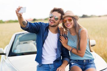 Wall Mural - Couple taking a selfie while out on a road trip
