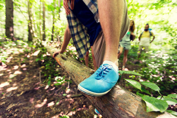 Canvas Print - close up of man climbing over tree trunk in woods