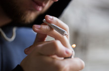 Close Up Of Addict Lighting Up Marijuana Joint