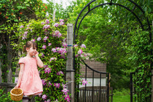 Smiling Girl By Garden Gate With Basket