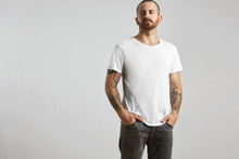 Attractive Brutal Tattooed Bearded Guy Poses In Black Jeans And Blank White T-shirt From Premium Thin Summer Cotton, Isolated On White Mockup