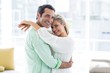 © WavebreakMediaMicro - Portrait of mid adult couple hugging at home