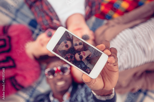Fotografía Picture of best friends making selfies on mobile or smart phone while spending free time on picnic in parklane