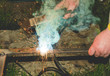 sparks from the welding machine/hands hold iron on which sparks from the welding machine fly