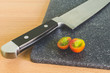 knife on a chopping board the cut tomato/kitchen knife on a chopping board the tomato cut red with green