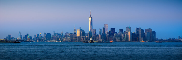 Fototapete - Panoramic Lower Manhattan Financial District skyscrapers and New York City Harbor at twilight