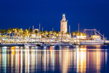 Lighthouse "La Farola" Located On The Paseo De La Farola On The East Side Of The Harbor Of Malaga. Spain