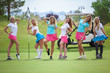 Group of young female golf caddies on golf course.