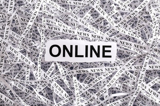 Closeup torn pieces and tapes of paper with the word ONLINE.