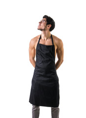 Wall Mural - Sexy shirtless young chef or waiter posing, wearing black apron on naked body, isolated on white background