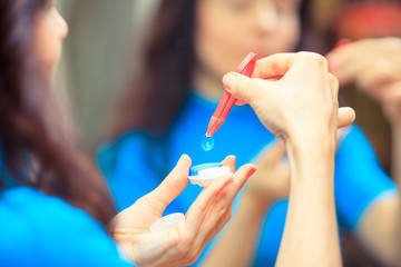 contact lenses in containers and tweezers, , on snellen eye char