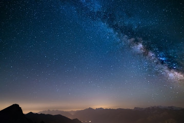 Wall Mural - glowing milky way and starry sky from the alps