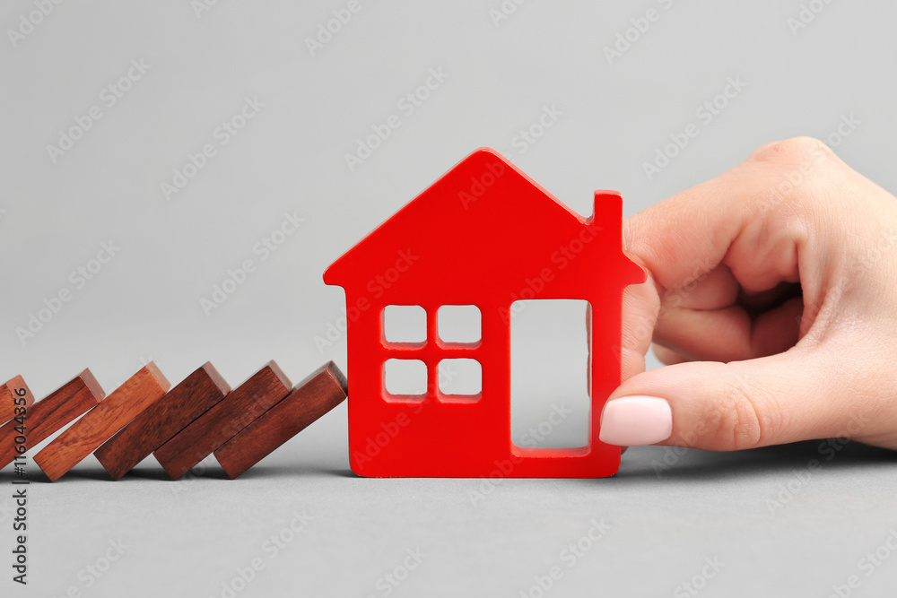 Dominoes and wooden house shape on grey background