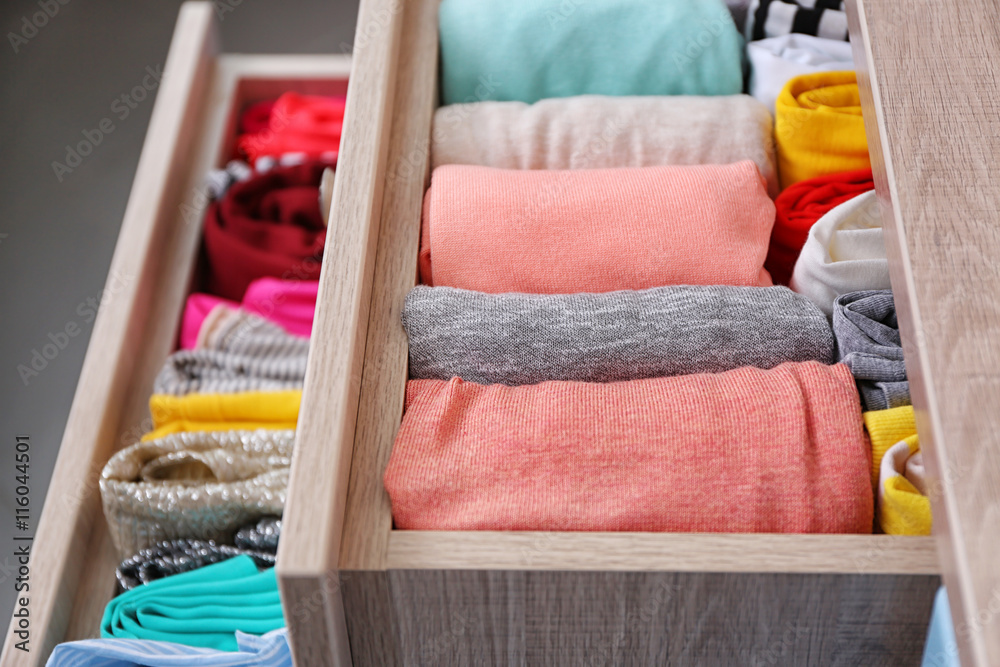 Neatly folded clothes in chest of drawers