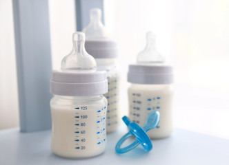 Fototapete - Baby milk bottles and pacifier on white background