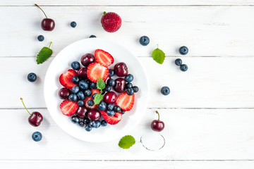 fruit salad on white wooden background, top view, flat lay