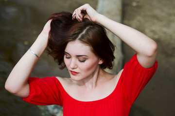 Fashion portrai young attractive woman in a red dress on the beach on a summer day

