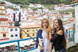 © ADDICTIVE STOCK - Two girls taking a selfie and having fun in a village.