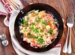 Scrambled eggs with ham, tomato and parsley